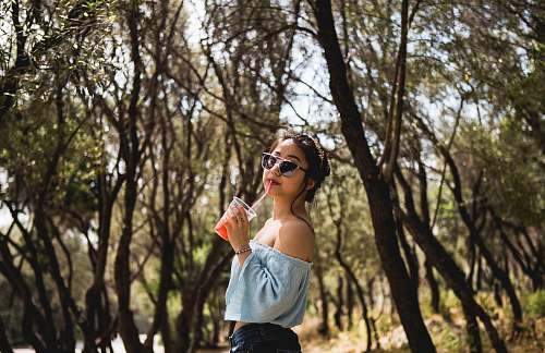 person woman standing near tree whike drinking human