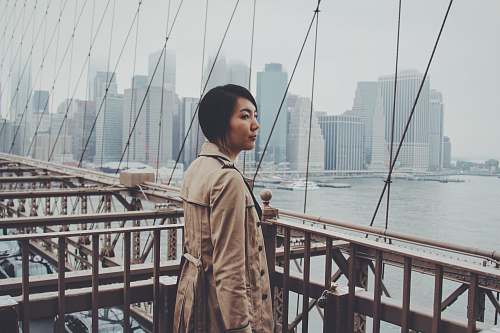 person woman standing on bridge railings at daytime new york