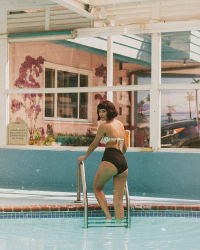 person woman standing on pool ladder at daytime human