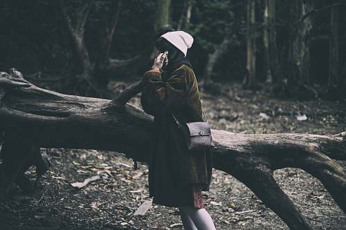 person woman standing on tree part during daytime beanie