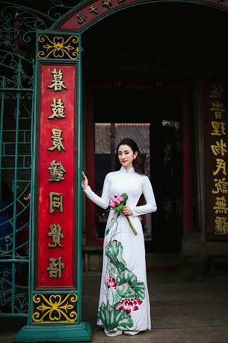 human woman standing while holding flowers person