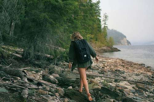 human woman walking on rocky seashore person