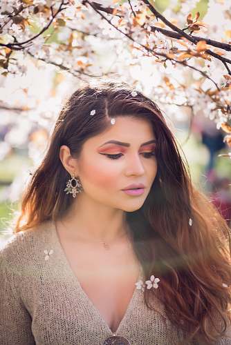 person woman wearing brown top standing near brown and white leafed tree during daytime\ human