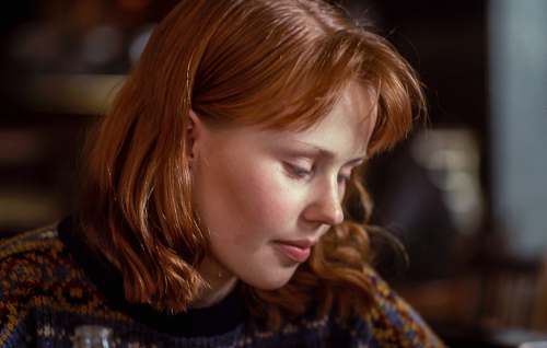 person woman wearing knit top near chair human