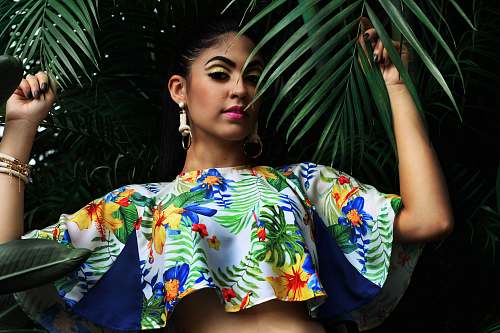 woman woman wearing multicolored floral crop-top holding green palm leaves fashion