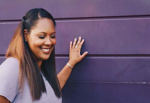 human woman wearing purple shirt touching the wall woman