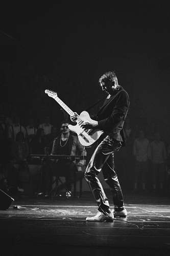 black-and-white grayscale photography of man playing electric guitar near man playing electric keyboard music