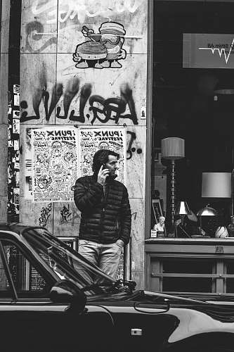 people grayscale photography of man using cellphone black-and-white