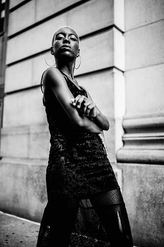 people grayscale photography of woman standing near wall black-and-white