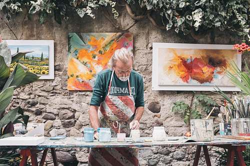 people man in white and red apron holding paint brush human