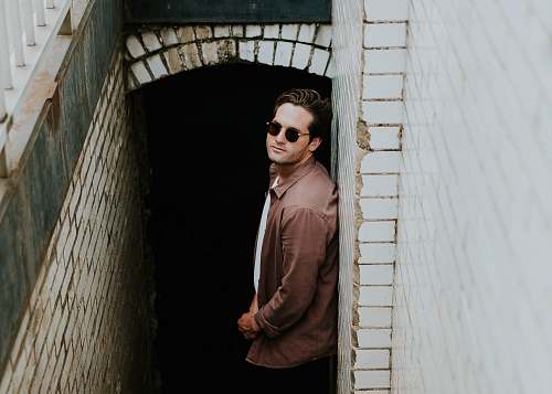 people man leaning on beige wall near hallway human