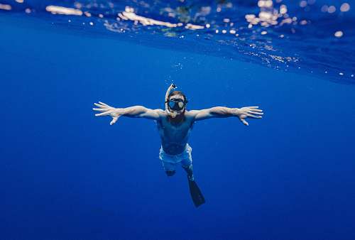 people man snorkling underwater blue