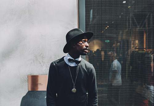 people man standing beside metal screen fence fashion