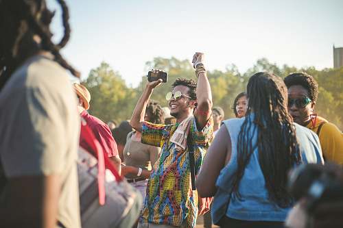 people man wearing multicolored shirt dancing in the middle of crowd human