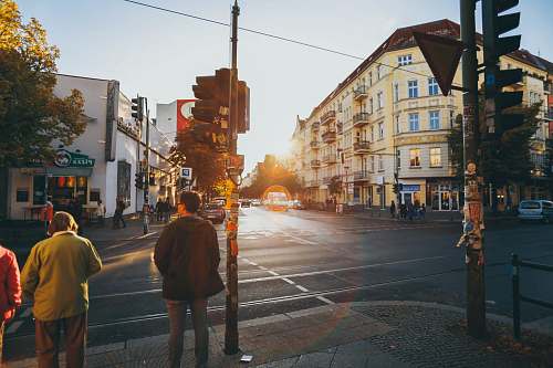 people men walking near concrete buildings intersection