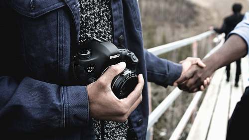 people person holding Canon DSLR camera human