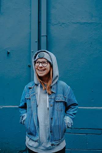 people woman in blue jacket standing beside walls human