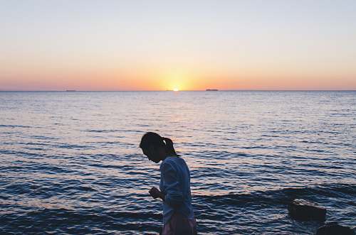 people woman in blue long-sleeved shirt near body of water water