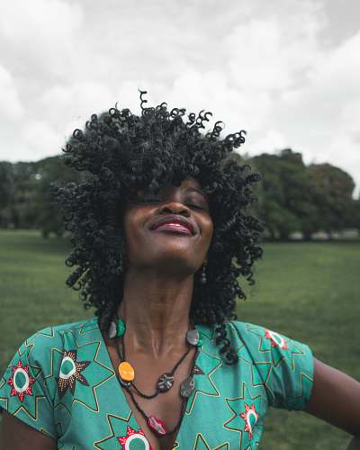 people woman in green plunging neckline top with right arm on her waist hair