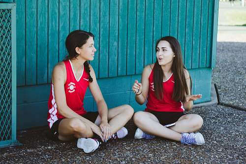 people woman in red Nike tank top sitting beside woman in red tank top human