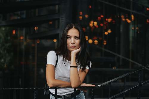 people woman leaning on black handrail woman