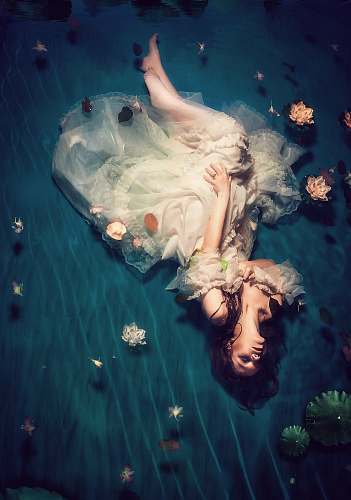 people woman wearing dress and lying on teal cloth human