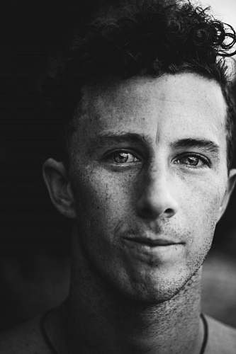 black-and-white grayscale photo of man smiling looking at camera face