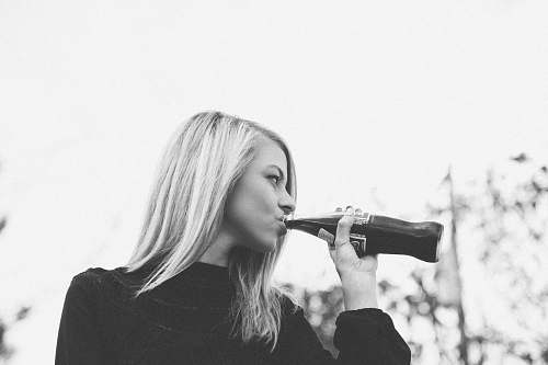 black-and-white woman drinking soda bottle blonde