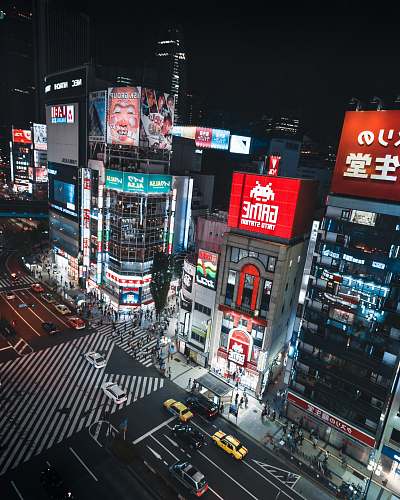 city aerial photography of commercial buildings and vehicles on road during nighttime metropolis