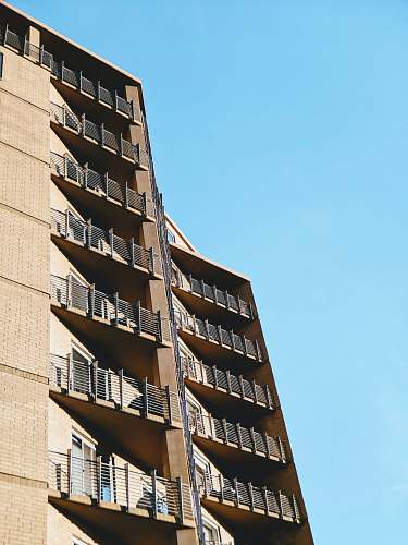 city beige concrete building at daytime high rise