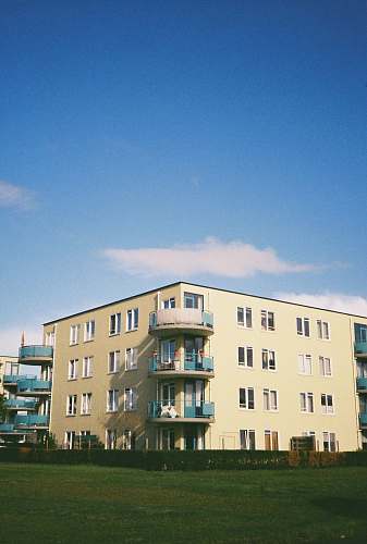 city beige concrete building under blue sky during daytime high rise