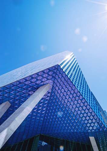 urban blue glass walled building under blue skies office building