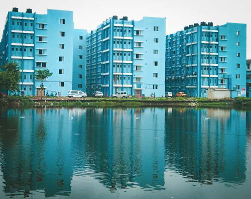 city blue painted buildings beside body of water high rise