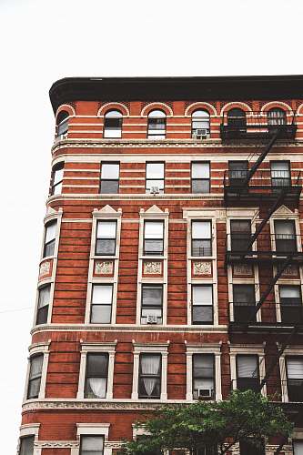 city brown concrete building under white sky high rise
