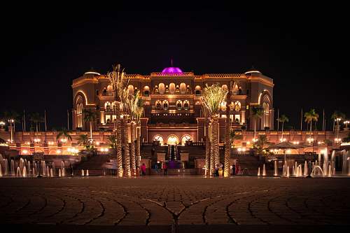 city brown mansion with lights during nighttime urban