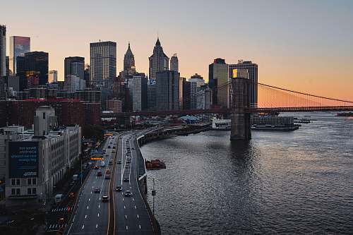 city buildings and road beside body of water urban