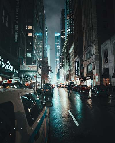 city cars on road near buildings metropolis