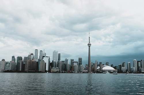 city city buildings near body of water under cloudy sky during daytime high rise