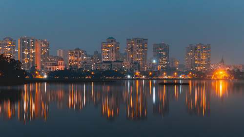 city city with high-rise buildings near body of water during night time urban