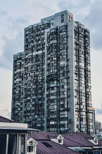 city curtain wall building beside house at daytime high rise