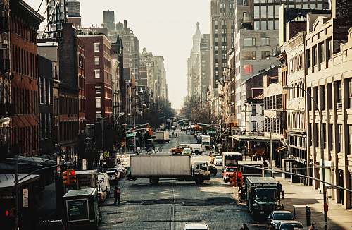 city different cars on road near buildings metropolis