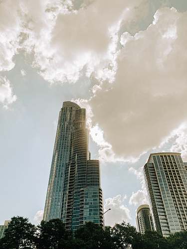 city gray concrete building under white clouds high rise