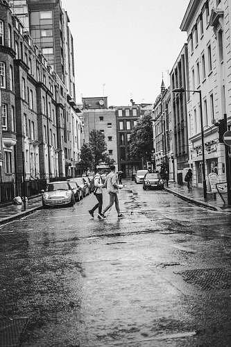 city grayscale photo of person walking on road black-and-white