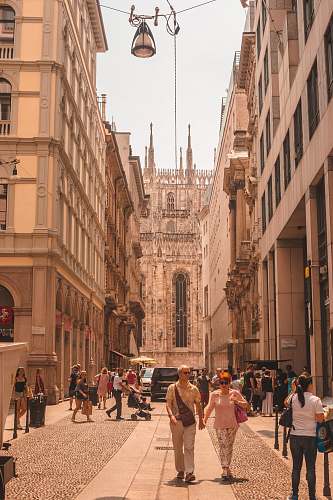 city group of people walking on street in between of buildings person