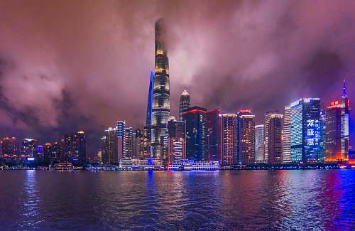 city lighted buildings near ocean during nighttime town