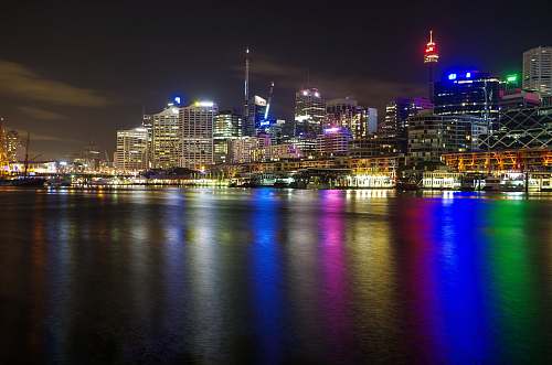 city lighted city beside sea water