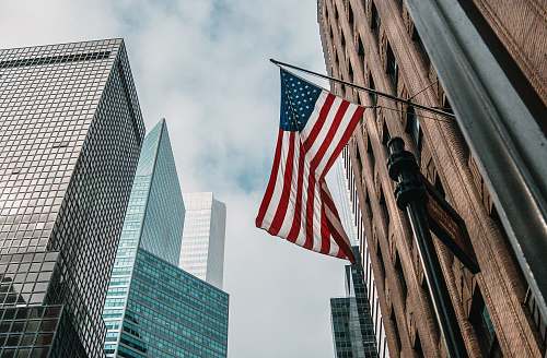 city low angle photo of flag of U.S.A architecture