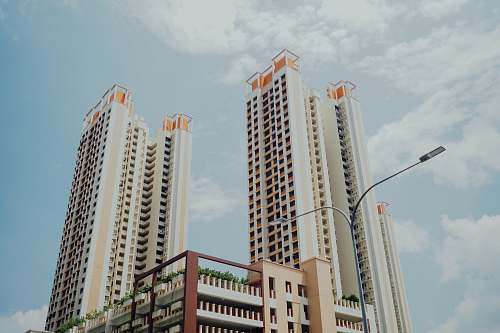 urban low-angle photo of white highrise buildings under blue loudy sky high rise