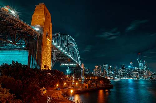 metropolis low-angle photograph of concrete and metal bridge at nightr town