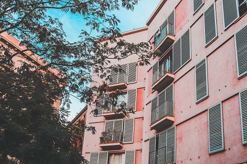city low-angle photography of pink concrete apartment during daytime home decor